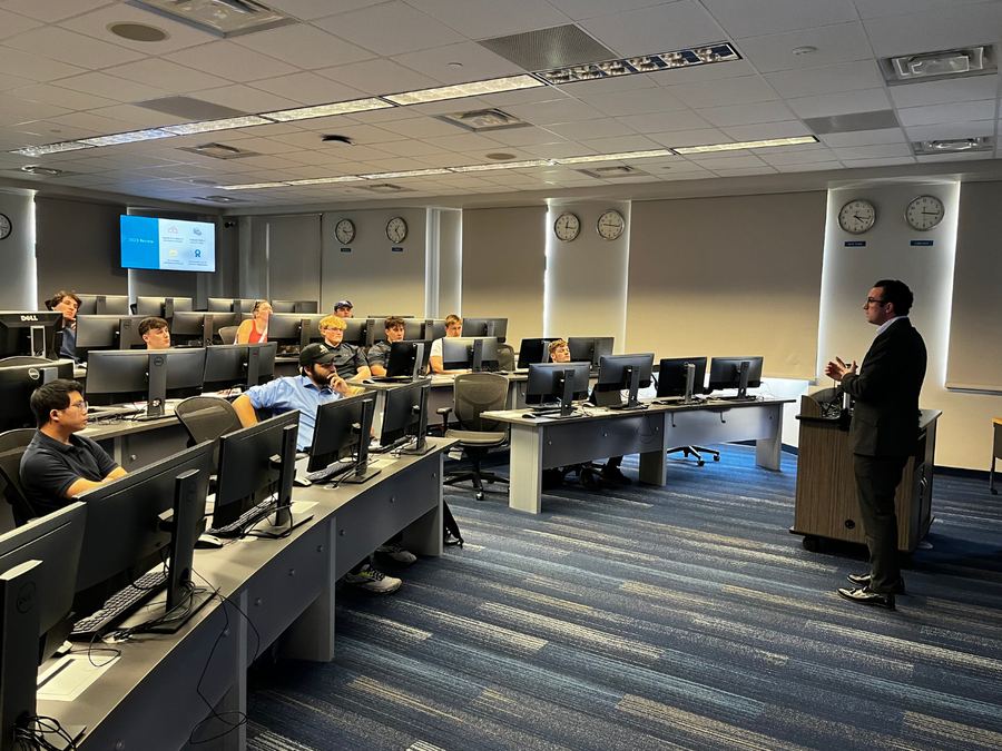 A presenter speaking to Finance Club members in the trading room